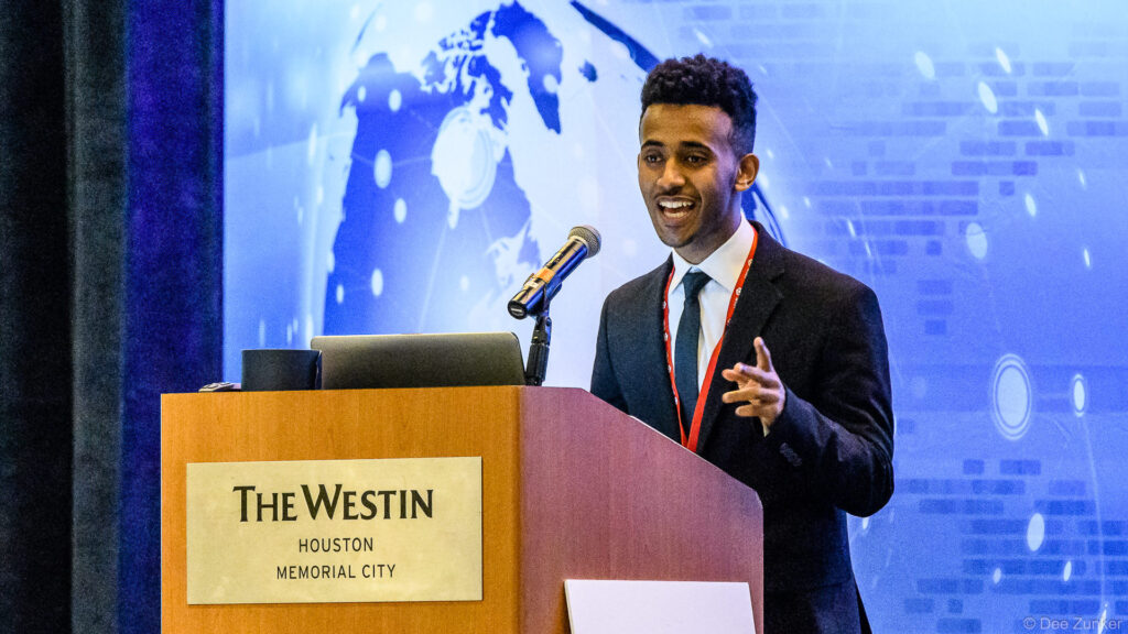 Young male speaker presents at podium during Houston IT Symposium conference at The Westin Houston Memorial City.