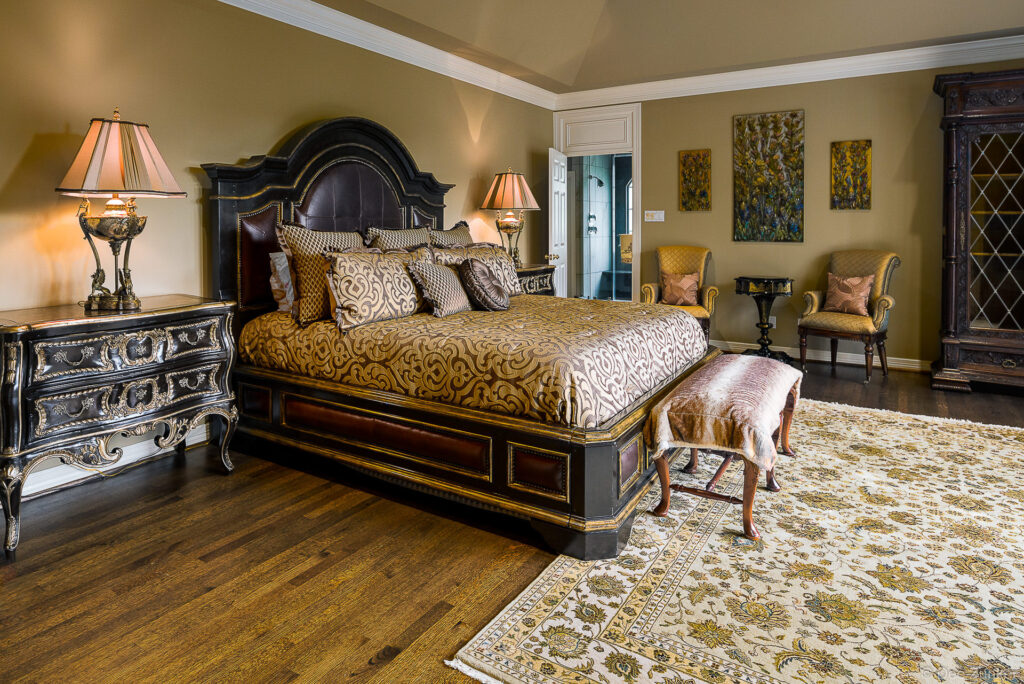 Ornate dark wood king bed with gold damask bedding in a luxury master bedroom at 5321 Sugar Hill, Houston TX.