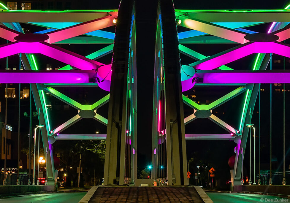 Colorful LED lighting illuminates the Montrose Boulevard Bridge steel truss structure at night in Houston, Texas