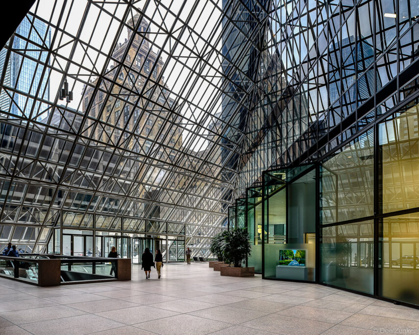 Glass atrium interior of Pennzoil Place Houston showcasing dramatic angular steel and glass architecture with city skyline visible above